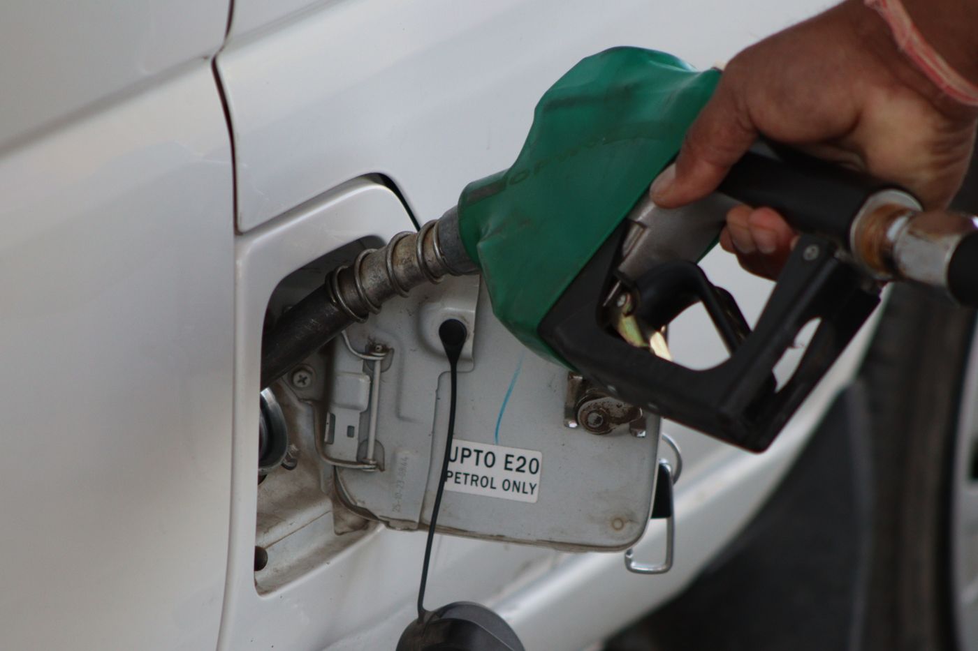 A vehicle being refuelled at a dispenser nozzle.